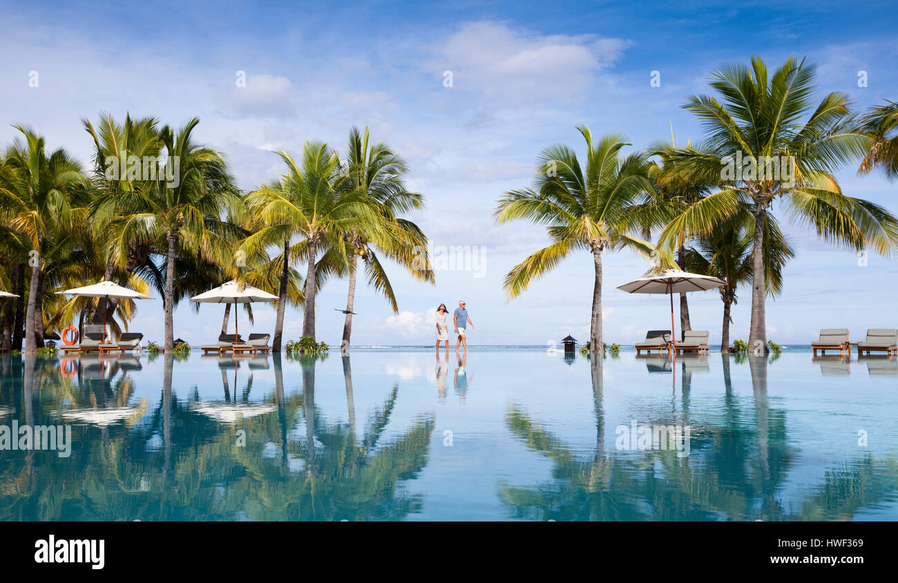 Honeymooners walking neer swimming pool. Luxurious five stars holiday resort on tropical paradise island Stock Photo