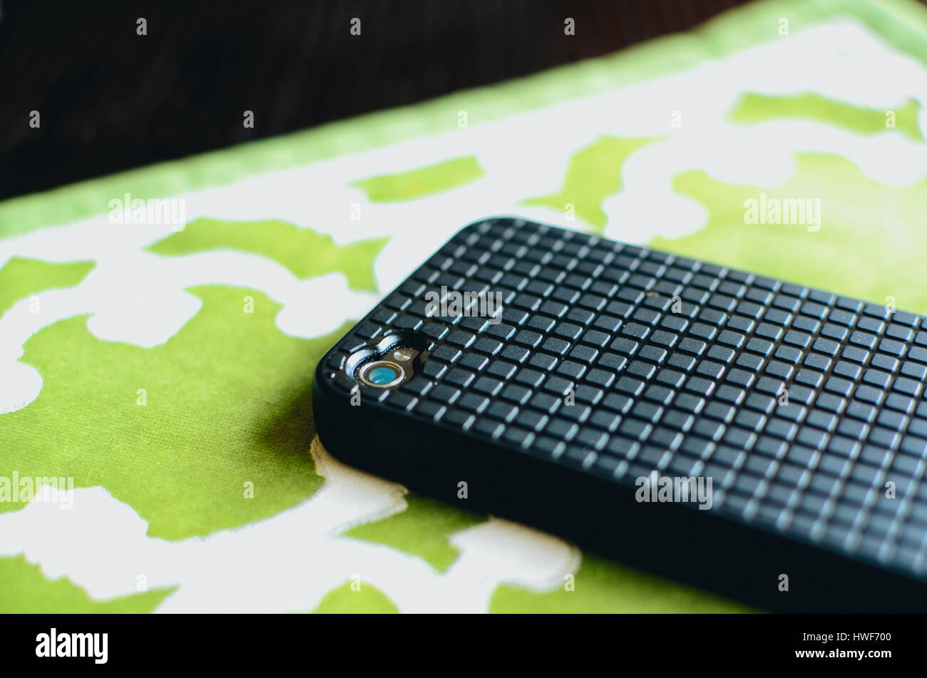 The back of a cell phone face down on the table. The case of the phone