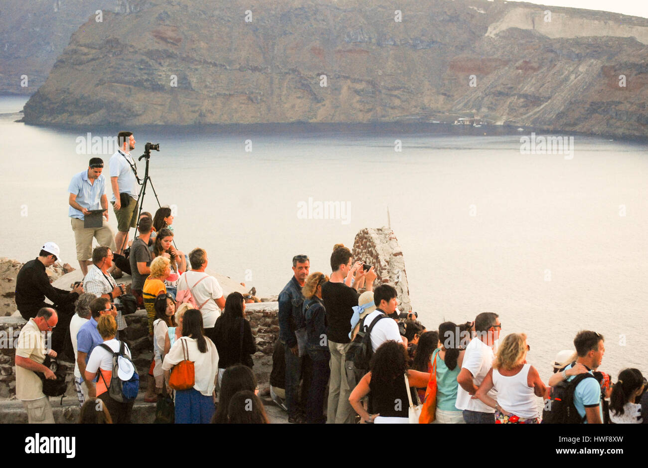 Sightseers gather for the sunset view from Oia on Santorini in the Greek Islands. Stock Photo