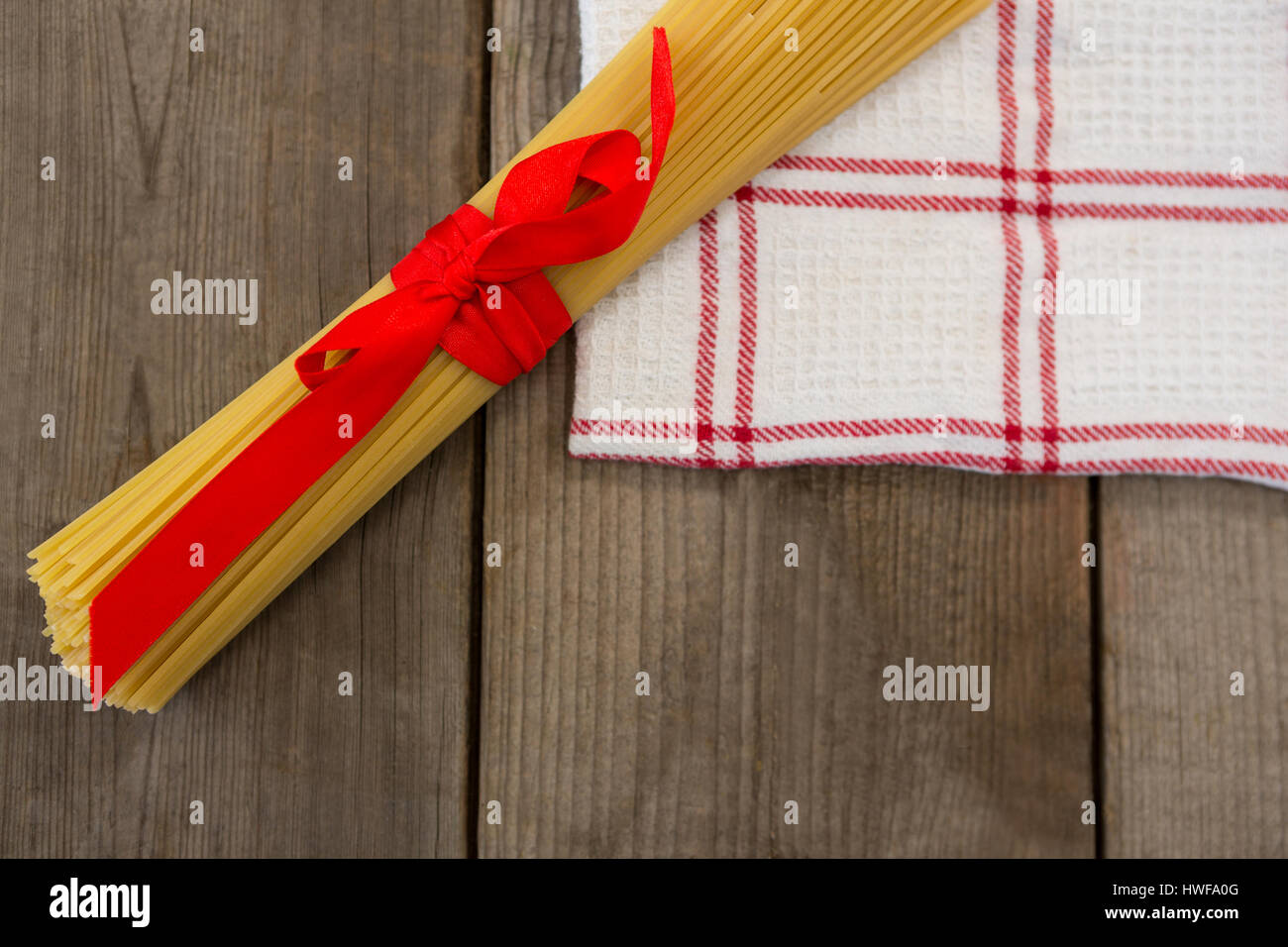 Spaghetti Ruby Ribbons Bundle of raw spaghetti tied with red ribbon on napkin Stock Photo - Alamy