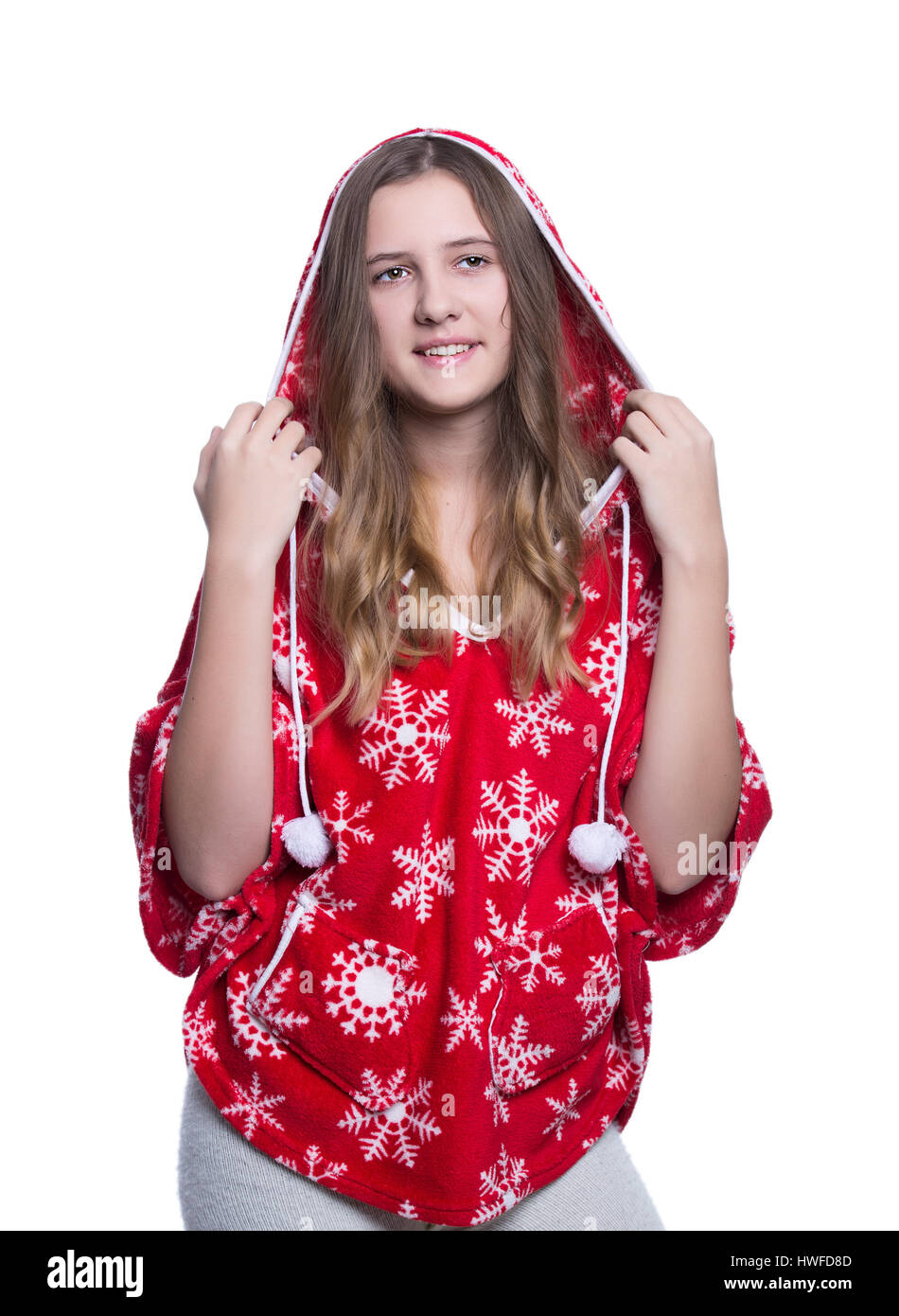 Lovely cheerful teenage girl posing in the studio. Wearing red winter hoodie with snowflakes. Isolated on white background. Winter clothes Stock Photo
