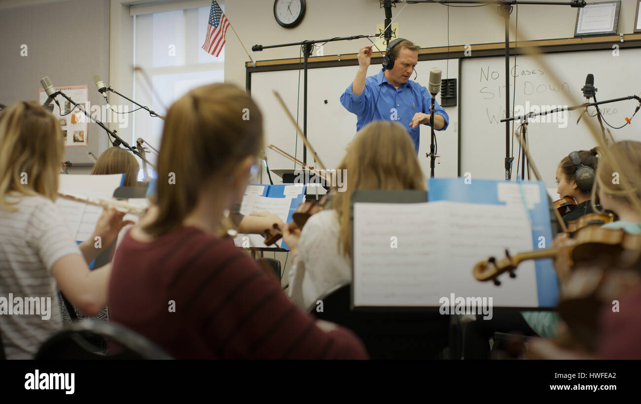 Selective focus view of teacher conducting musicians in band class Stock Photo