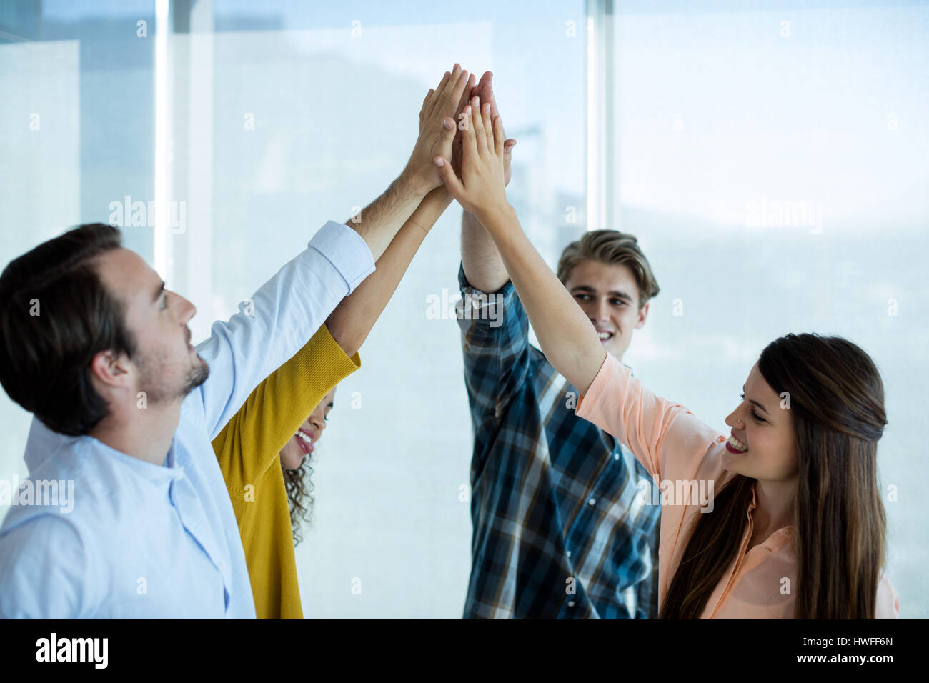 Creative business team giving a high five to each other in office Stock ...