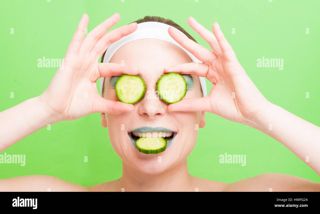 Young woman with cucumber slices on eyes hires stock photography and
