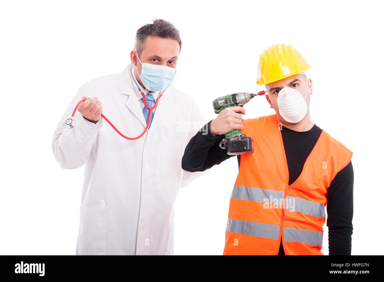 Silly doctor and constructor playing with their tools stethoscope and drill isolated on white background Stock Photo