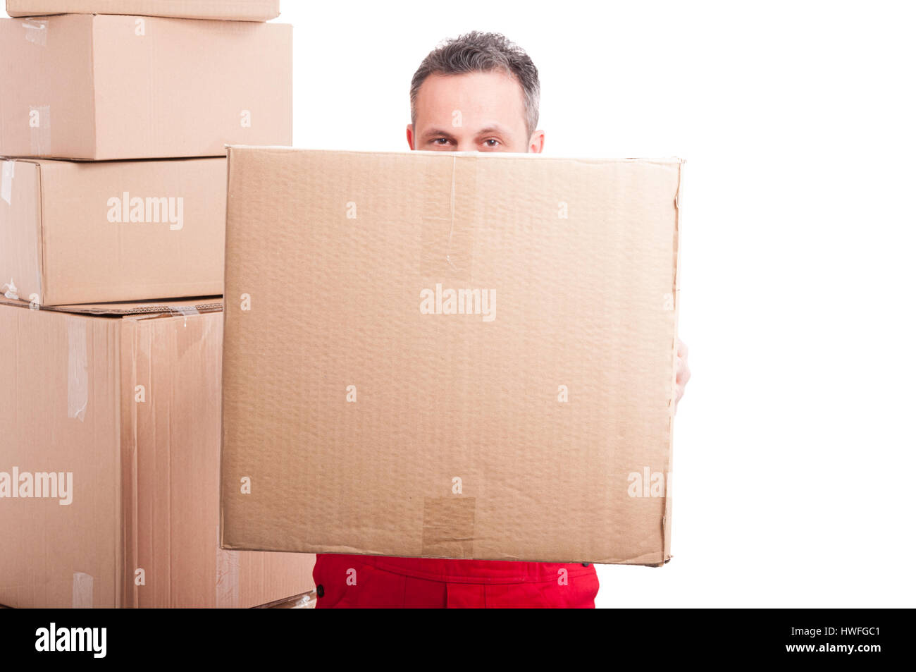 Mover guy hiding behind a big cardboard box isolated on white background Stock Photo