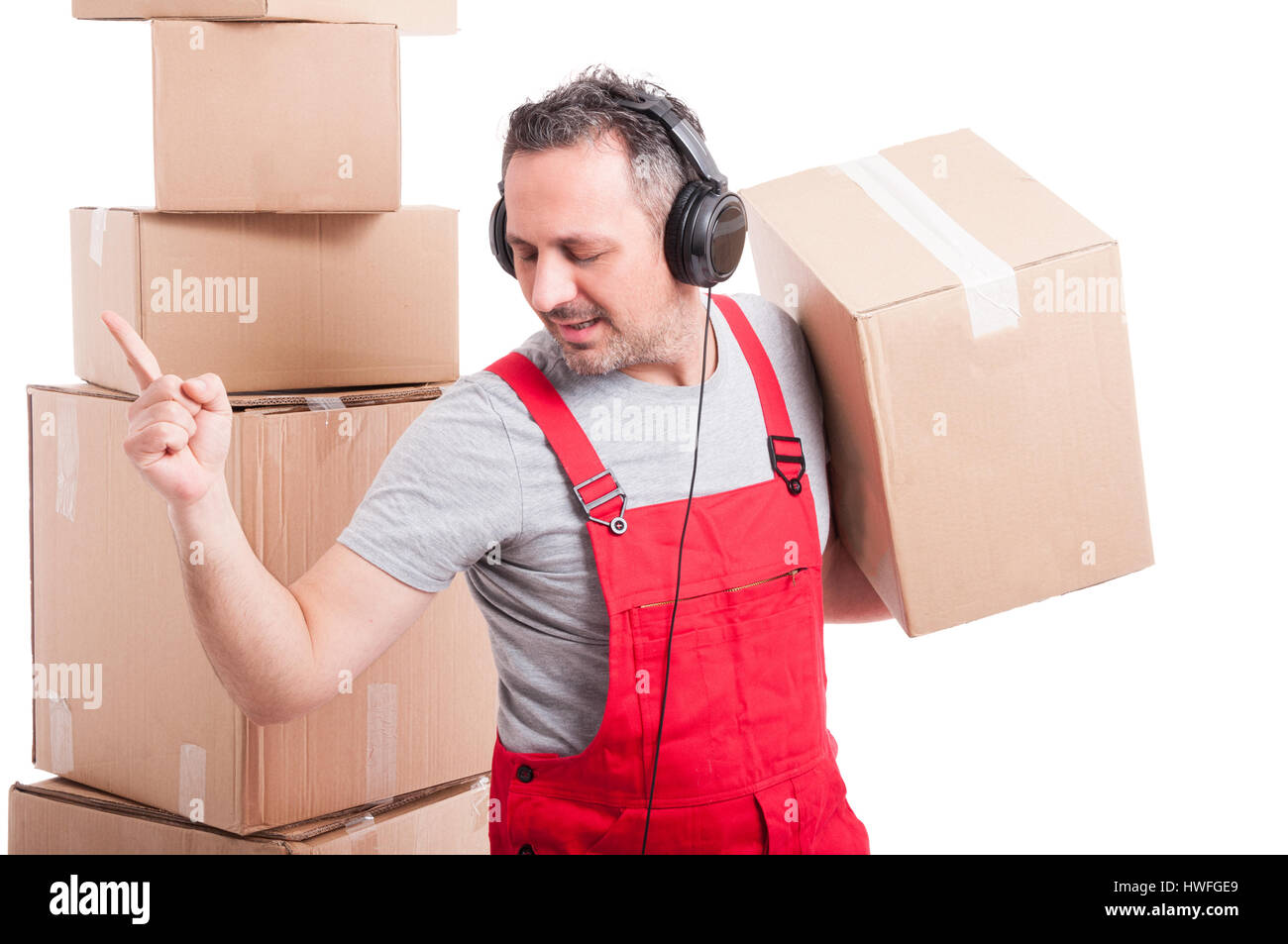 Mover man with headphones on enjoying music and dancing holding box
