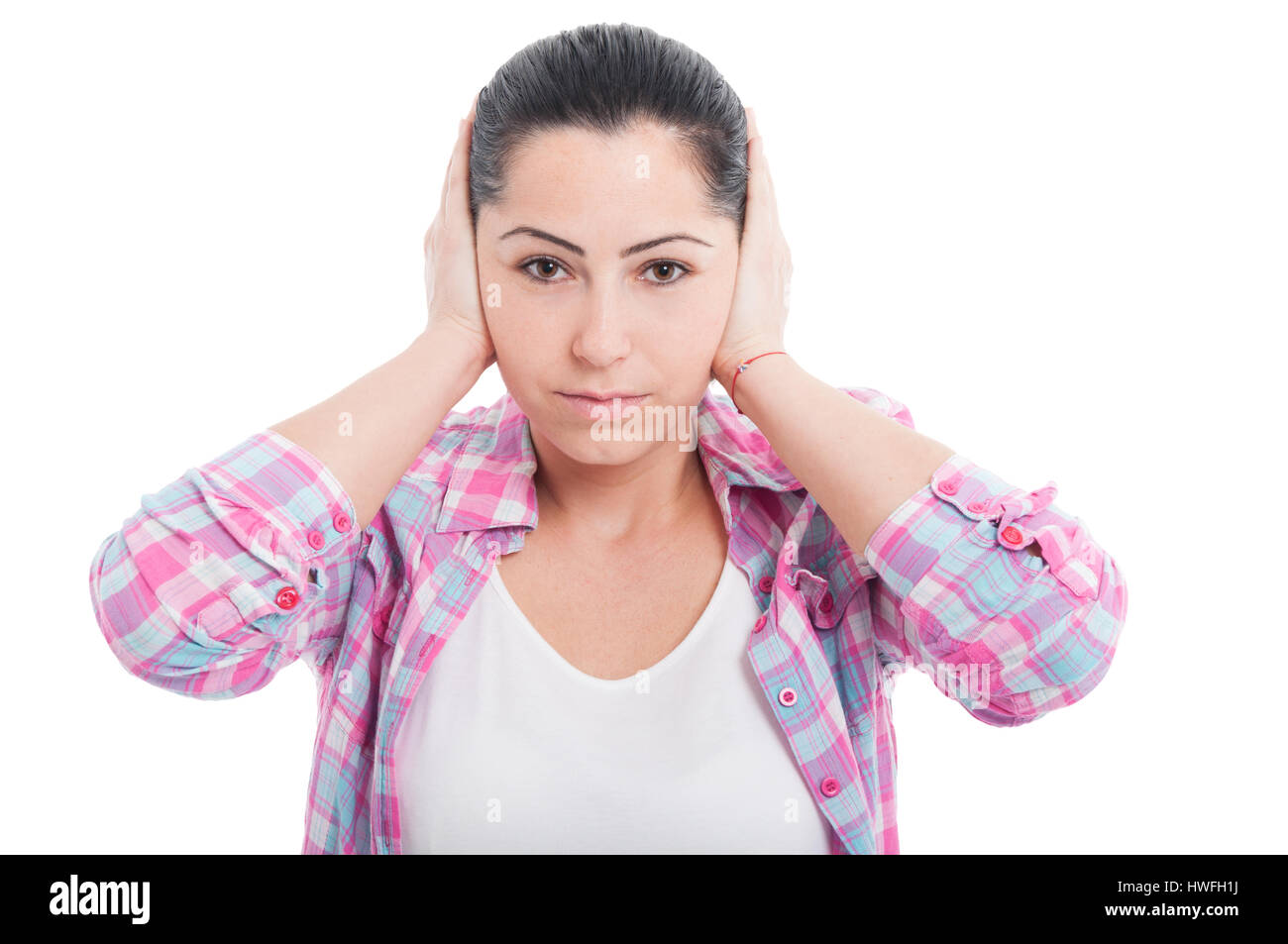 Portrait of beautiful woman doing hear no evil gesture by covering her ears on white background Stock Photo