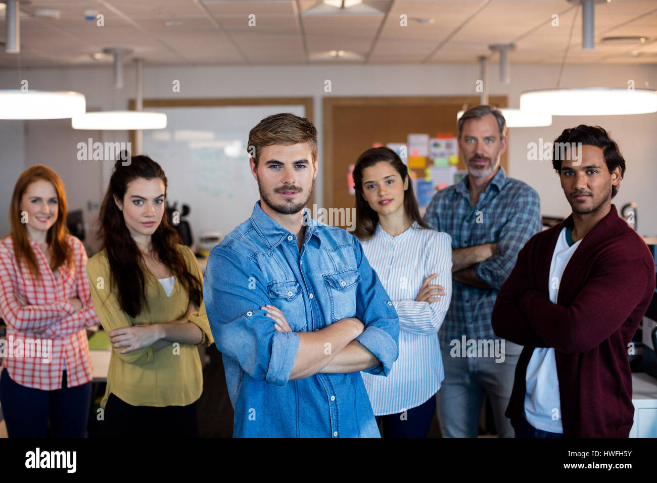 Portrait of creative business team standing together in office Stock ...