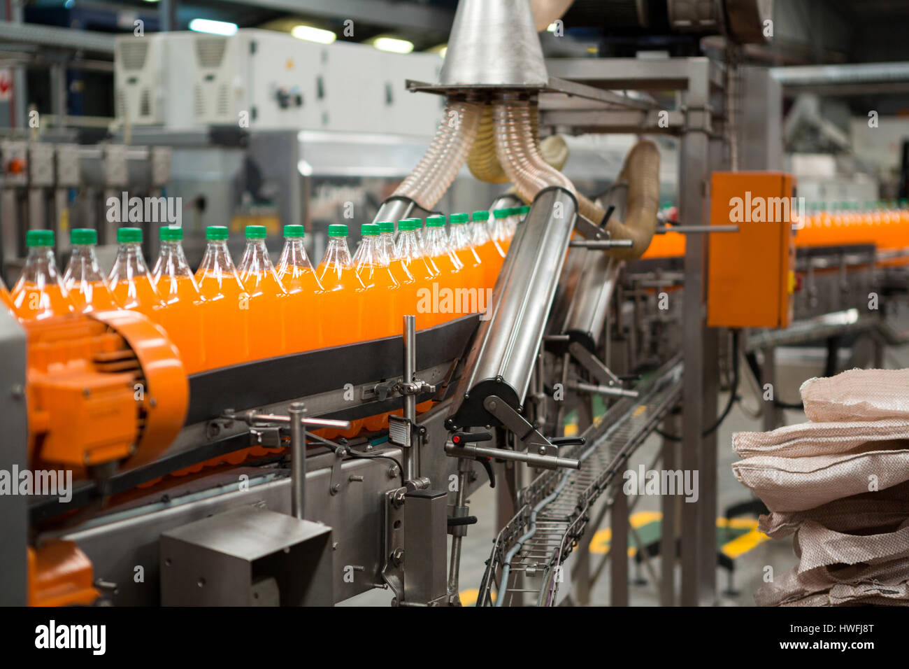 Packaging process of orange cold drink bottles in factory Stock Photo
