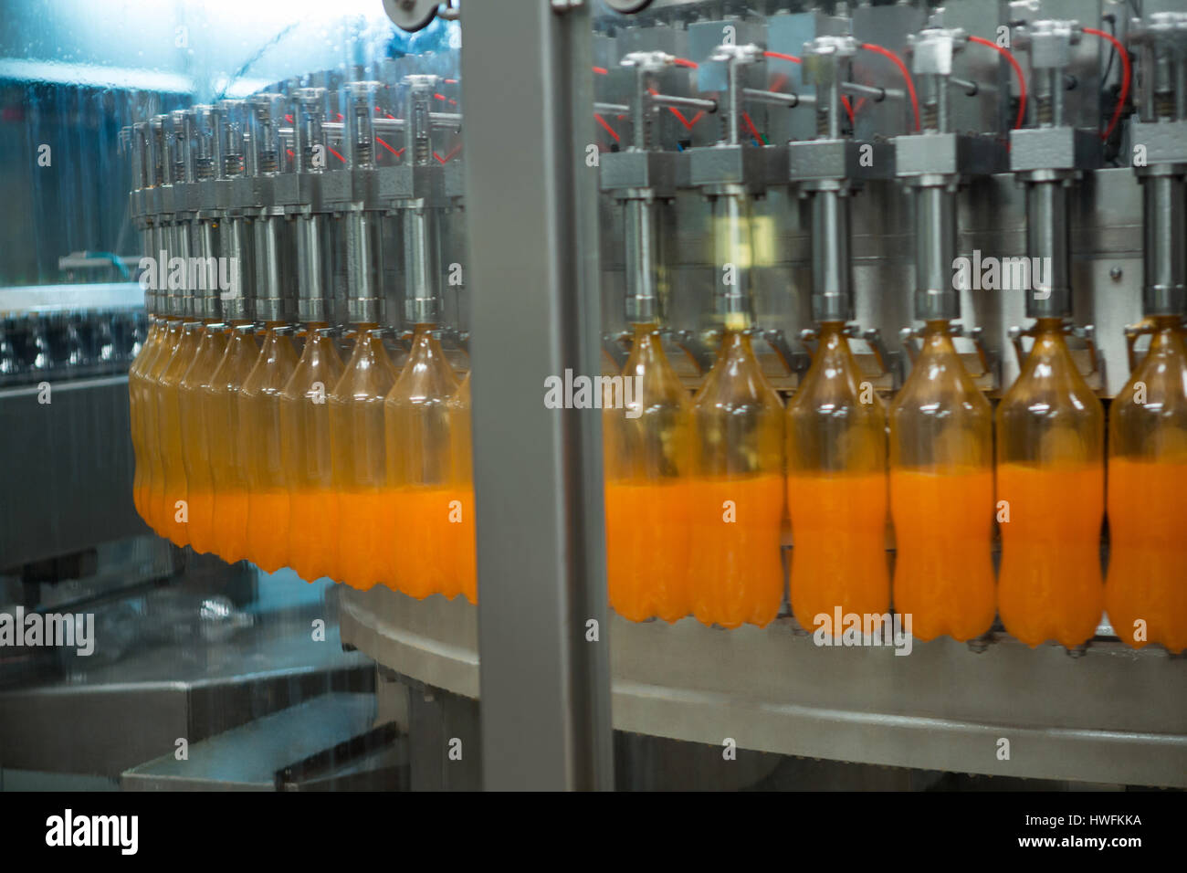 Bottles being filled with juice on production line at factory Stock Photo