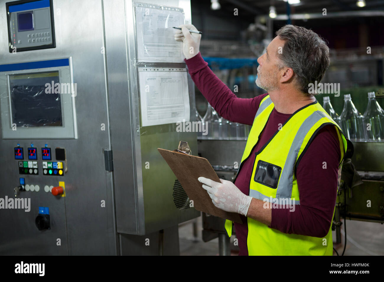 Senior manual worker analyzing machinery in factory Stock Photo