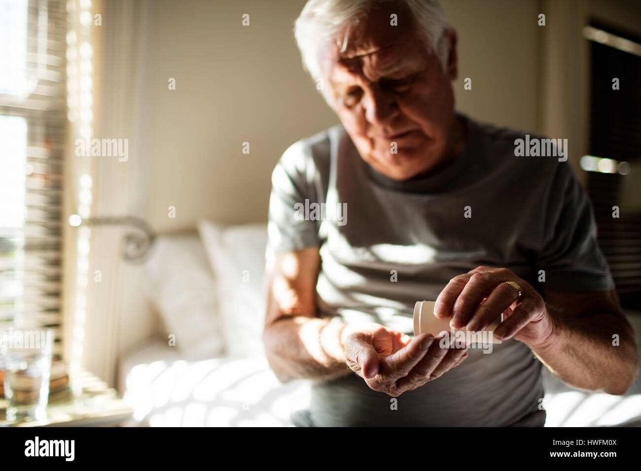 Senior man taking medicine in the bedroom at home Stock Photo