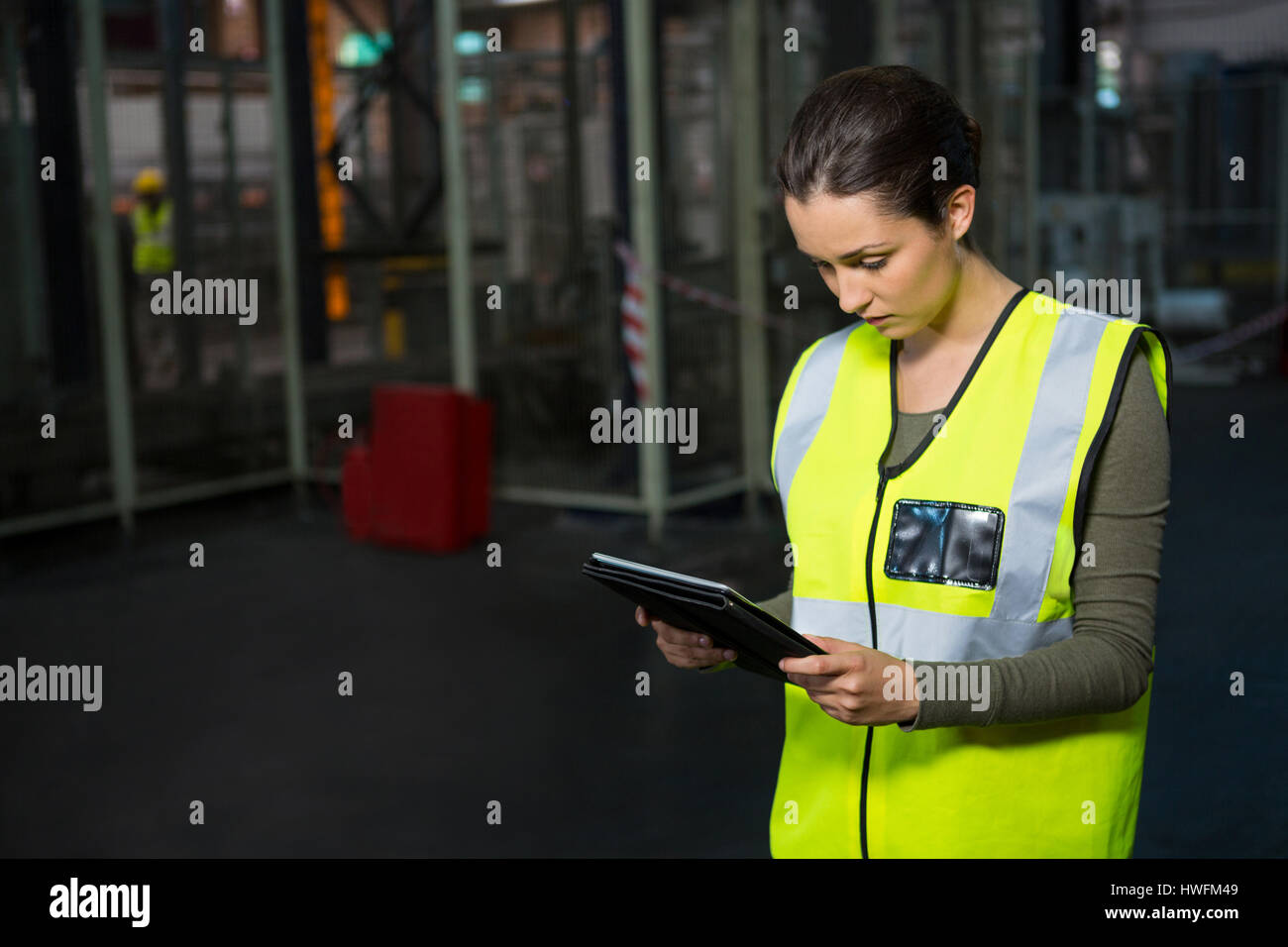Confident female worker using tablet pc in warehouse Stock Photo