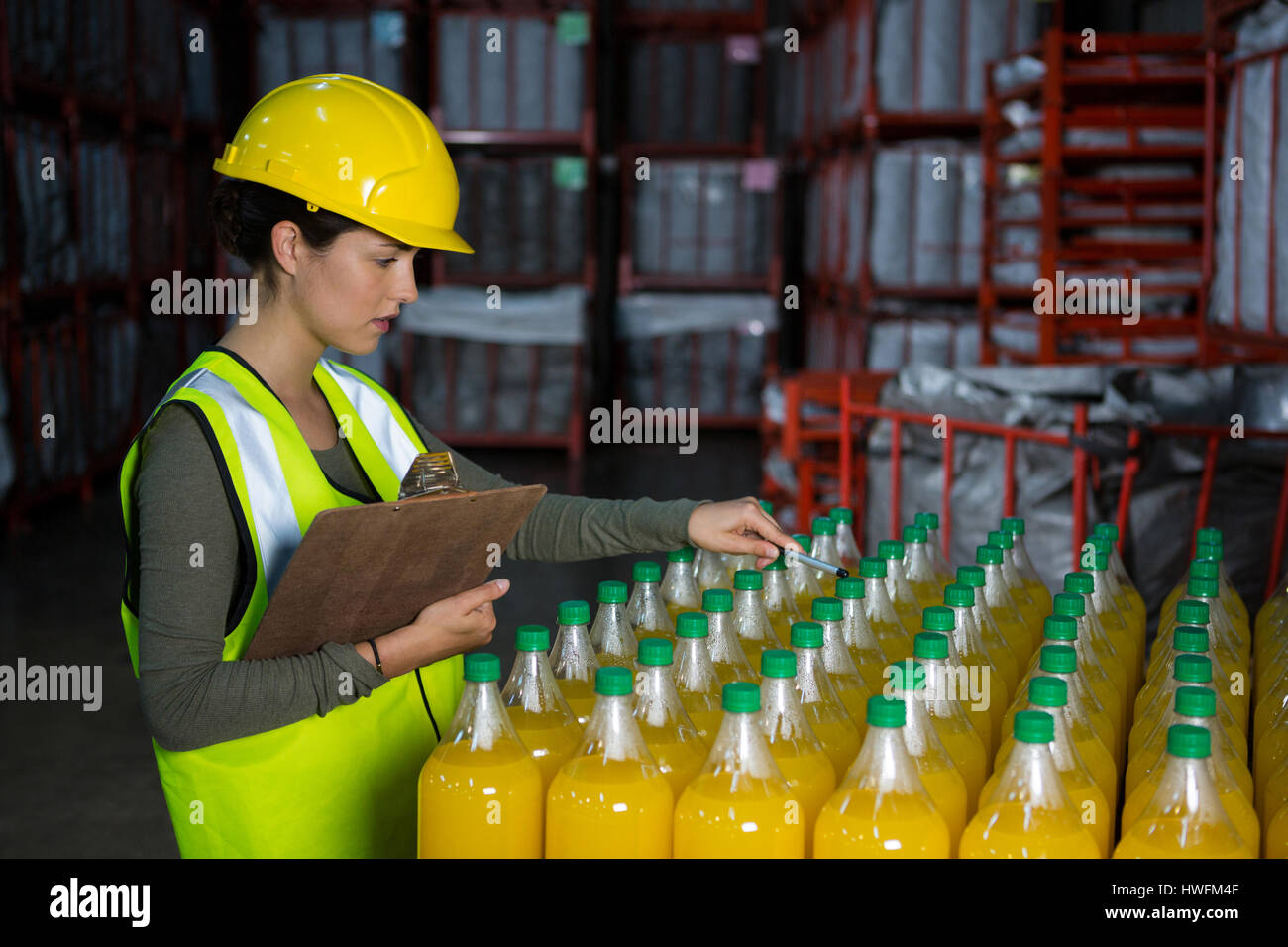 Female worker examining juice bottles in factory Stock Photo Alamy