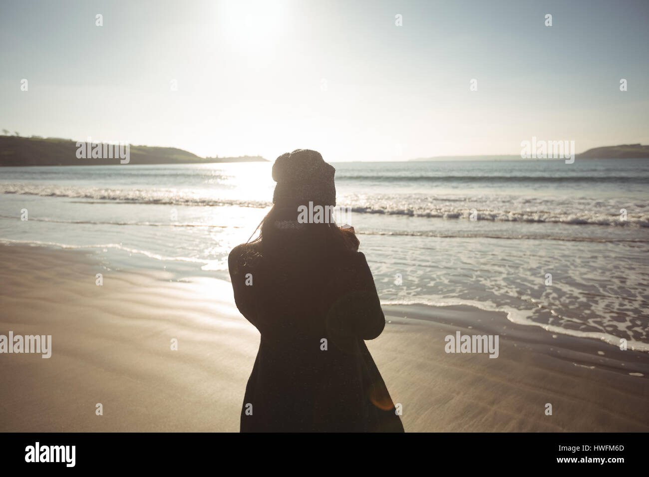 Rear view of woman standing on beach during day Stock Photo - Alamy