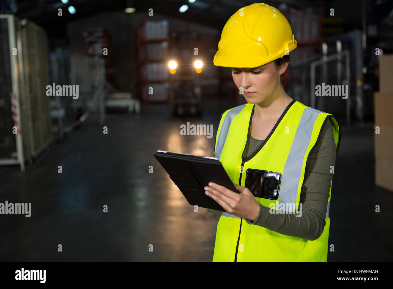 Portrait of beautiful young woman using tablet pc in factory Stock Photo