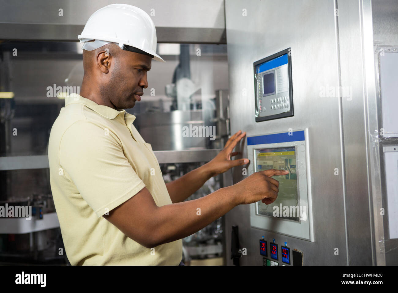 Confident male employee operating machine in manufacturing industry Stock Photo