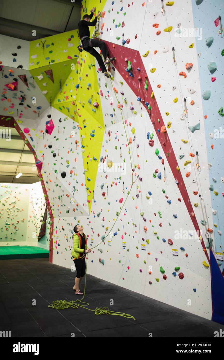 Man practicing rock climbing on artificial climbing wall in gym Stock Photo