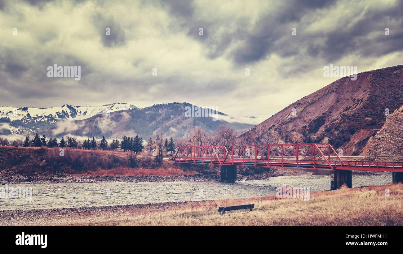 Red bridge in Rocky Mountains, color toning applied, Colorado, USA. Stock Photo