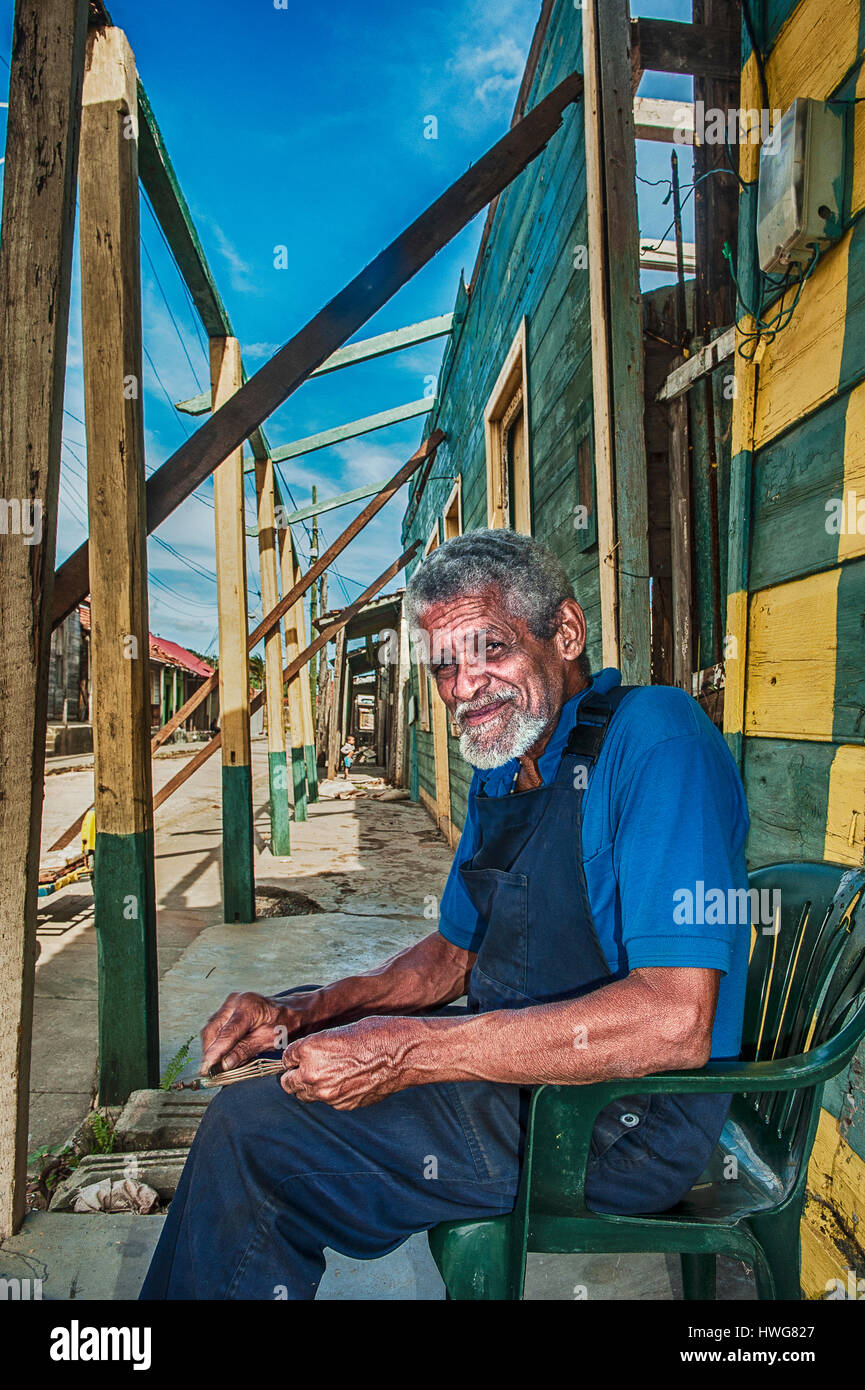 A man resting in front of an house partially destroyed by the hurricane ...
