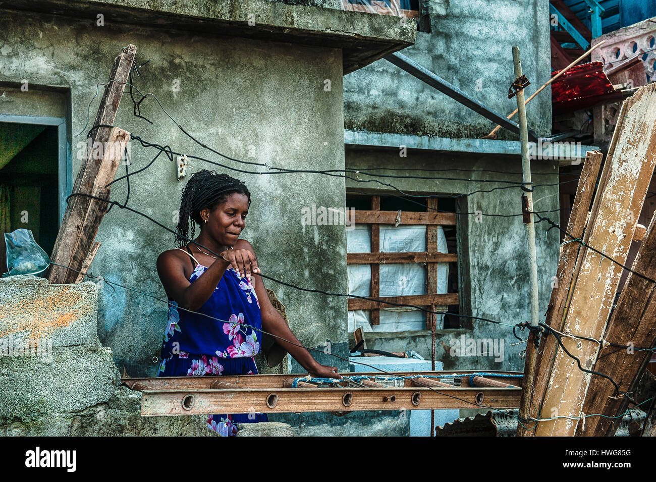 A woman thoughtfully in front of her house that has withstood the devastation of Hurricane Matthew in Baracoa, Cuba Stock Photo