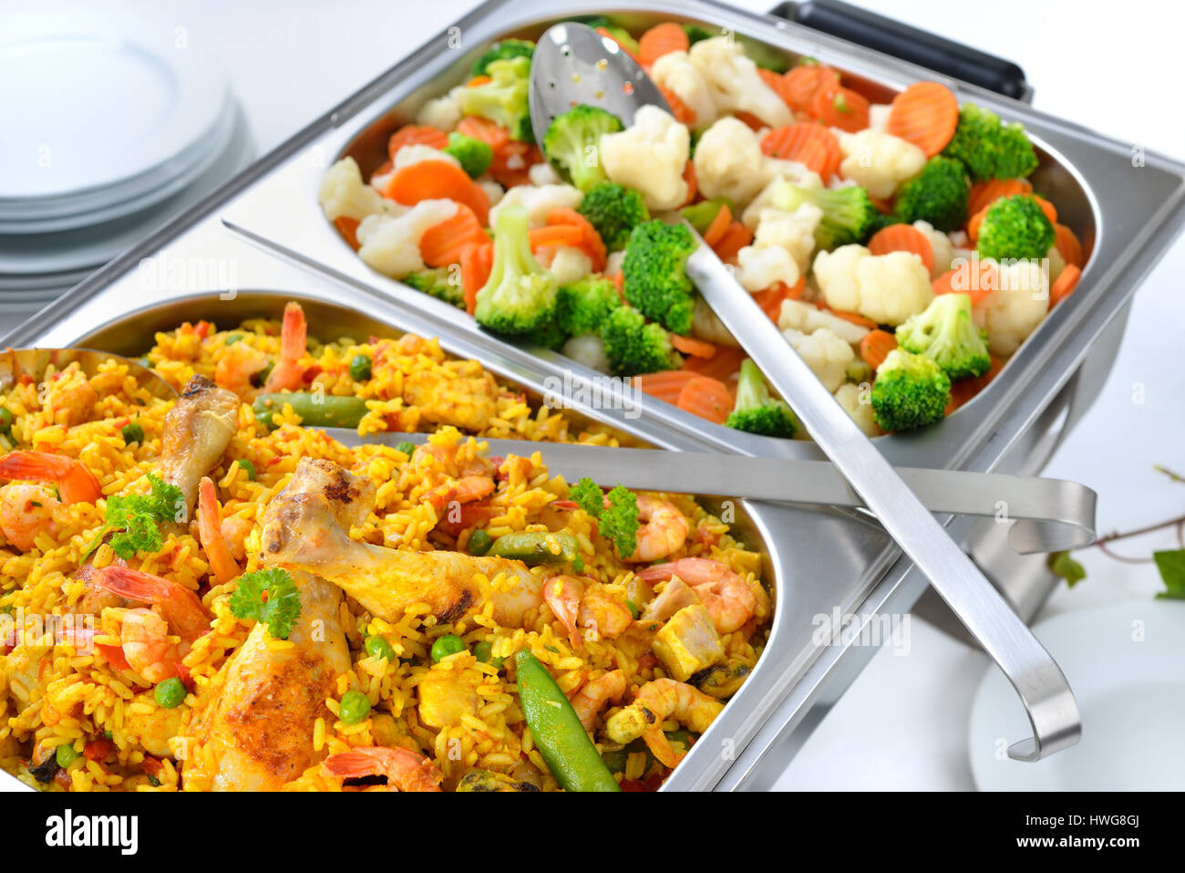 Warm buffet with Spanish paella and mixed buttered vegetables served in