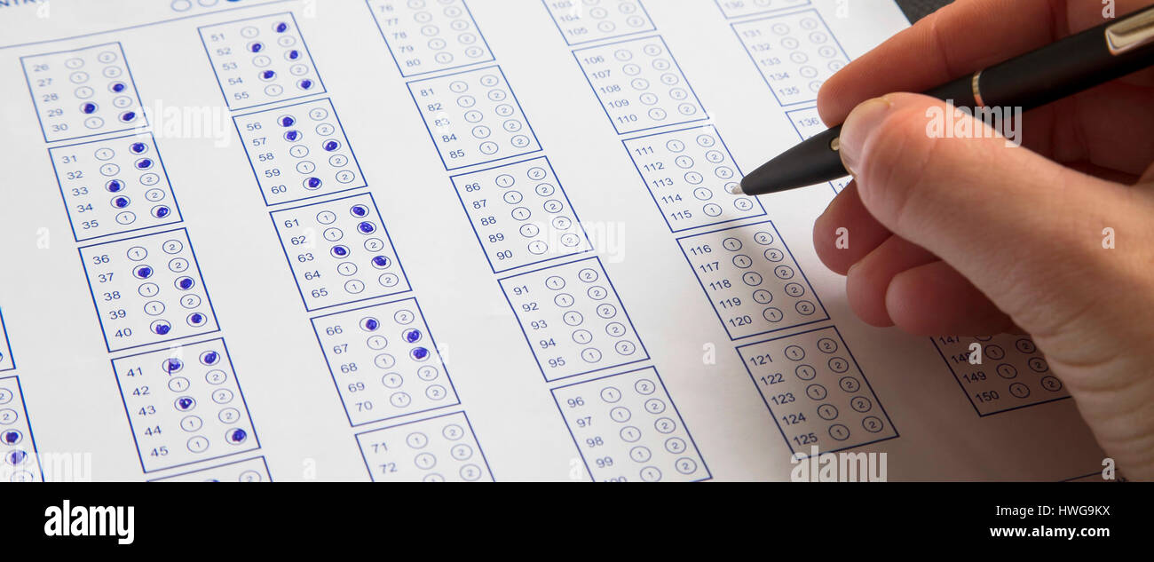 Filling exam questionnaire,hand with pen marking right answers at school or university Stock Photo