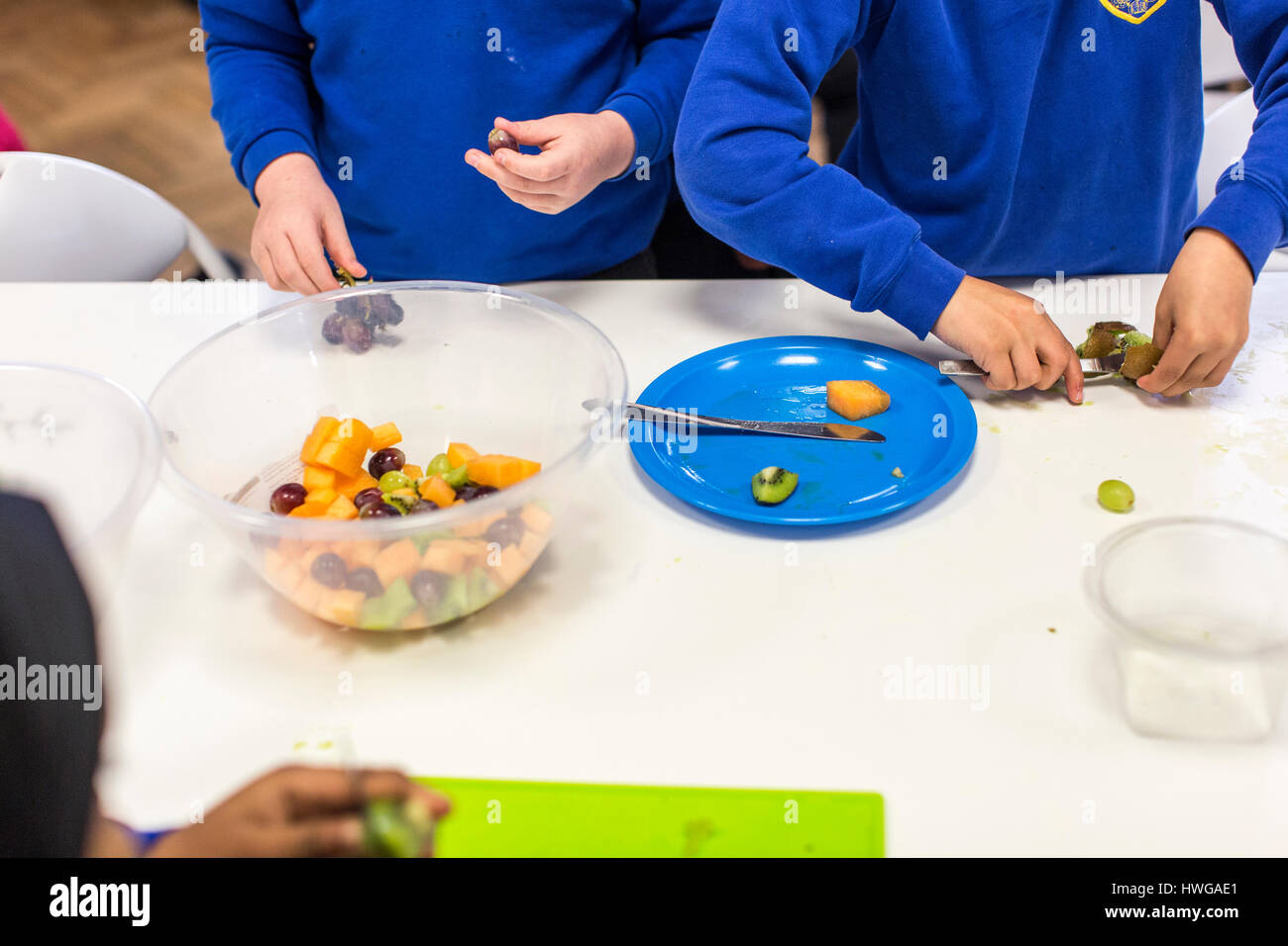 Primary School children prepare a fruit salad in an English school Stock Photo