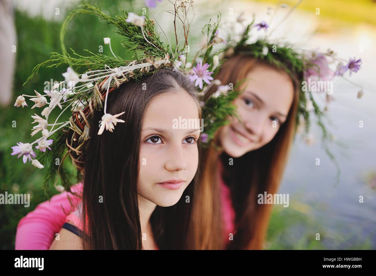 Two young girls in wreaths of wild flowers Stock Photo - Alamy