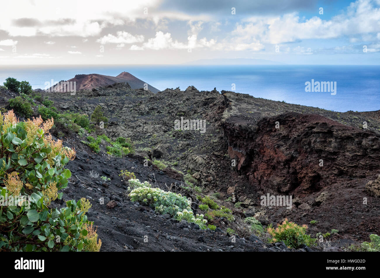 Cumbre Vieja, Fuencaliente. La Palma.  A view along the volcano's winding ridge and geological land formation. Very little vegetation grows in the lava rock of Cumbre Vieja region.  It's a bright day with fast moving clouds. Stock Photo
