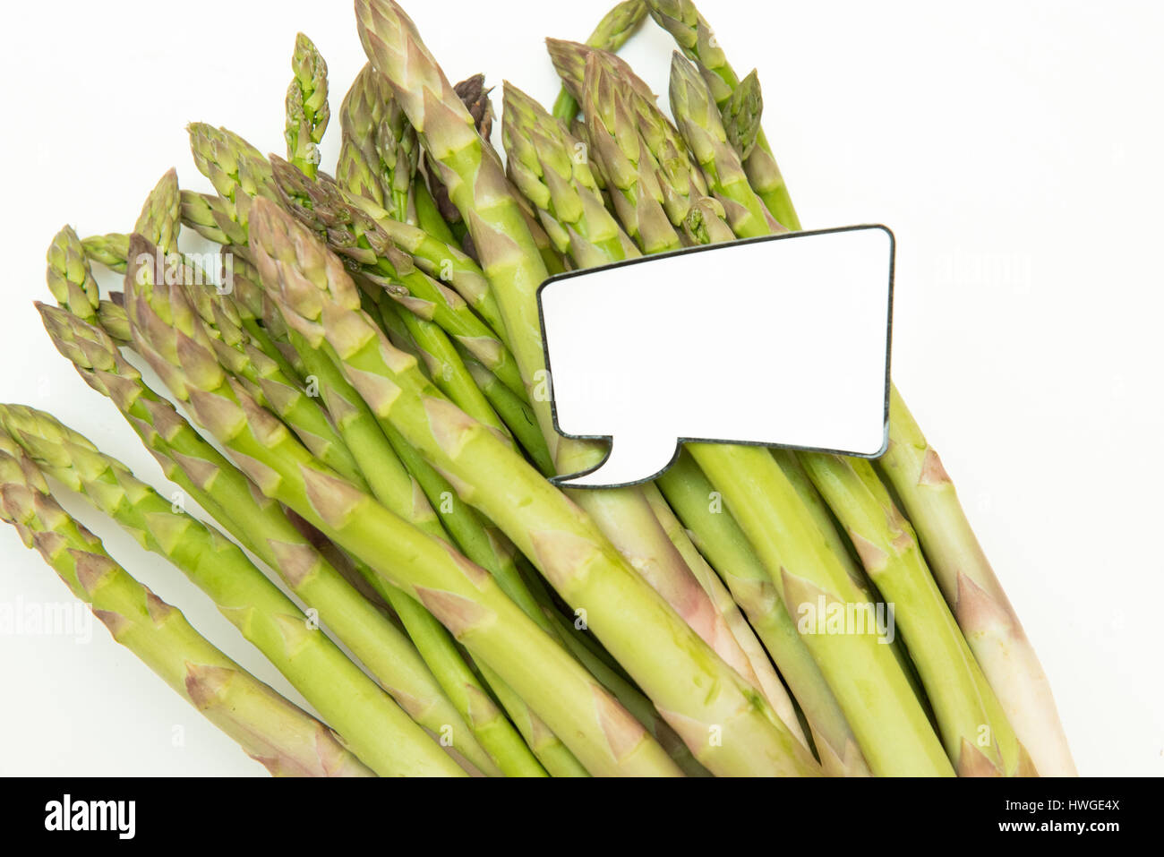 Bunch of fresh raw uncoocked asparagus and  funny comic style label for market price Stock Photo