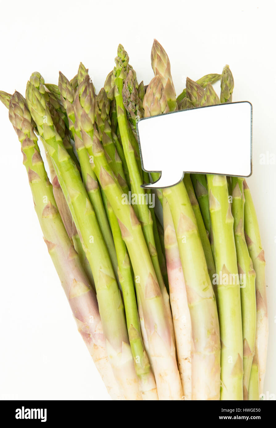 Bunch of fresh raw uncoocked asparagus and  funny comic style label for market price vertical frame Stock Photo
