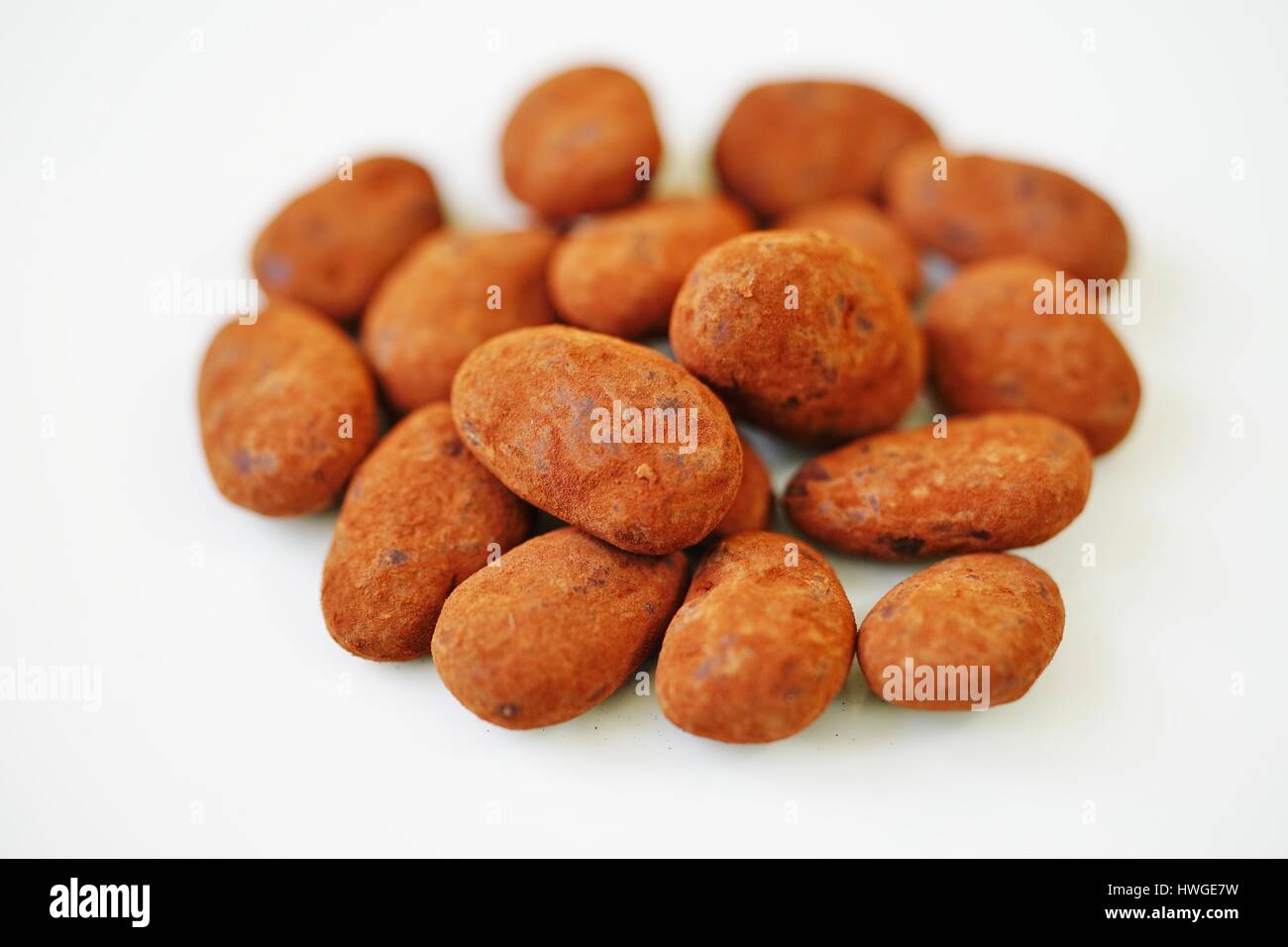 Whole almonds covered with French dark chocolate and cocoa powder on a
