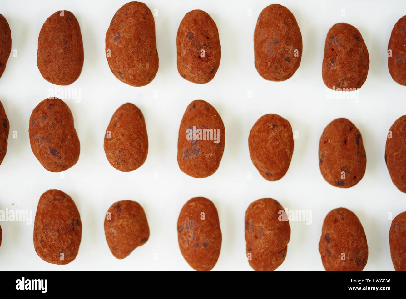 Whole almonds covered with French dark chocolate and cocoa powder on a