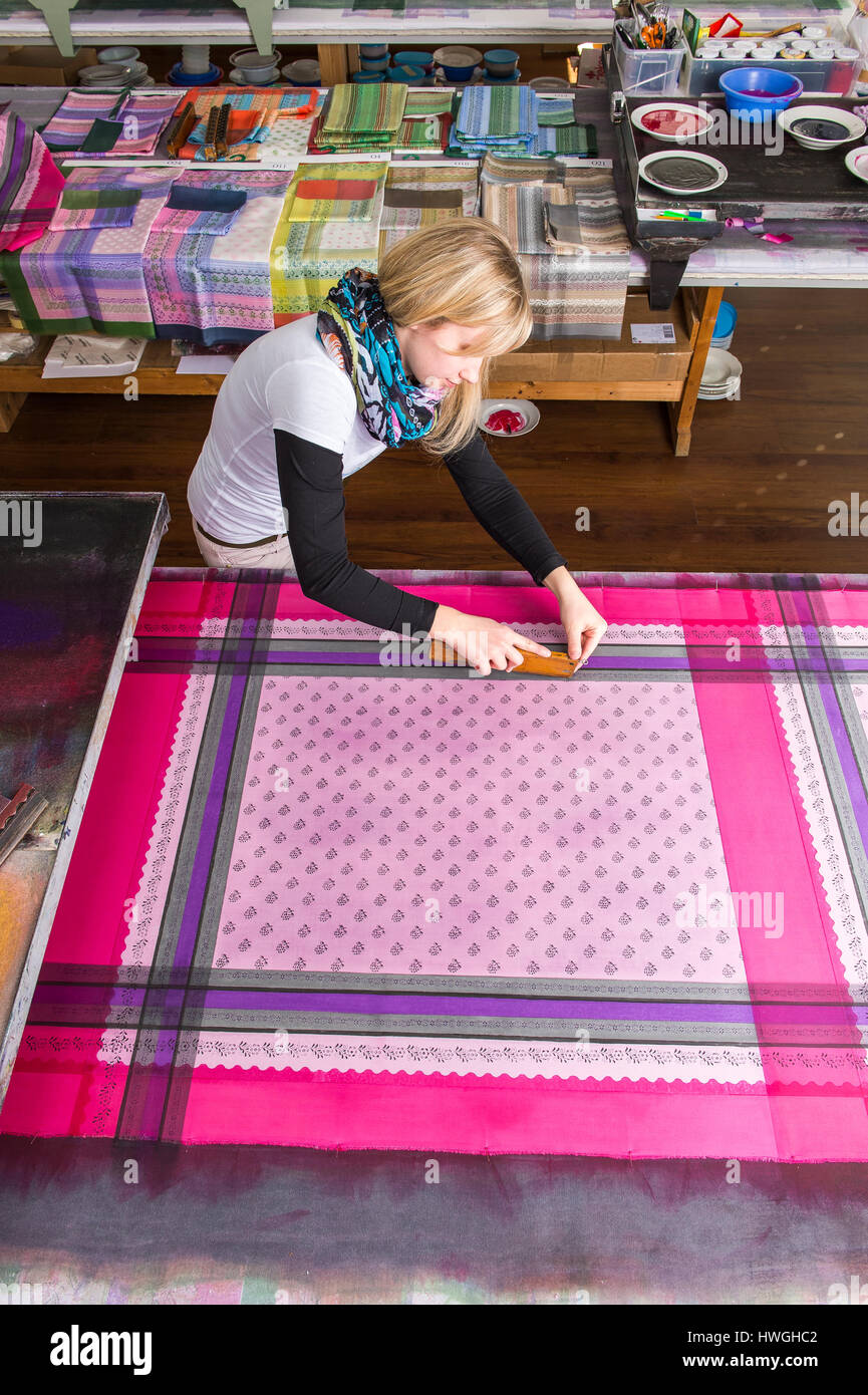 Block printing, woman pressing woodblock with paint on fabric, finished