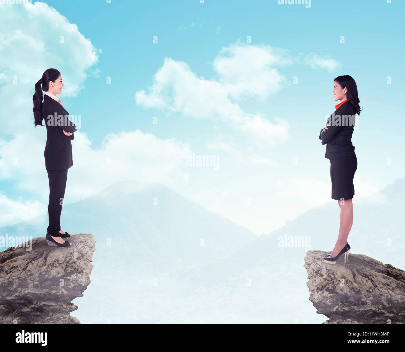 Two business woman standing on the top of the mountain. Business competition concept Stock Photo