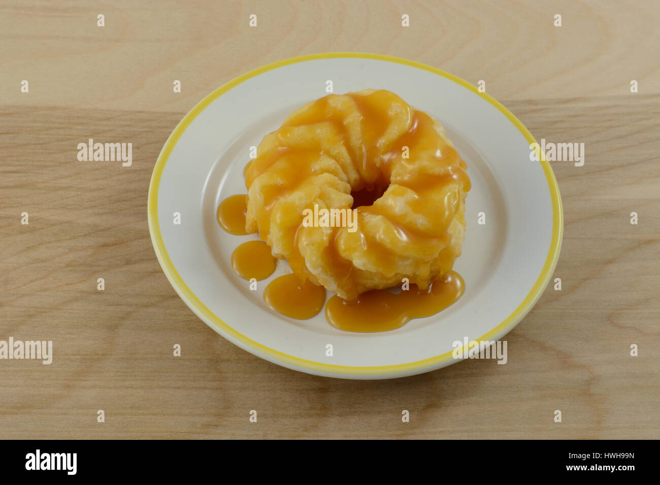 Decadent donut with butterscotch syrup on plate Stock Photo