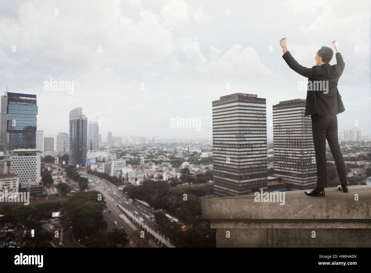 Business man shout on the building rooftop. Success in business concept Stock Photo