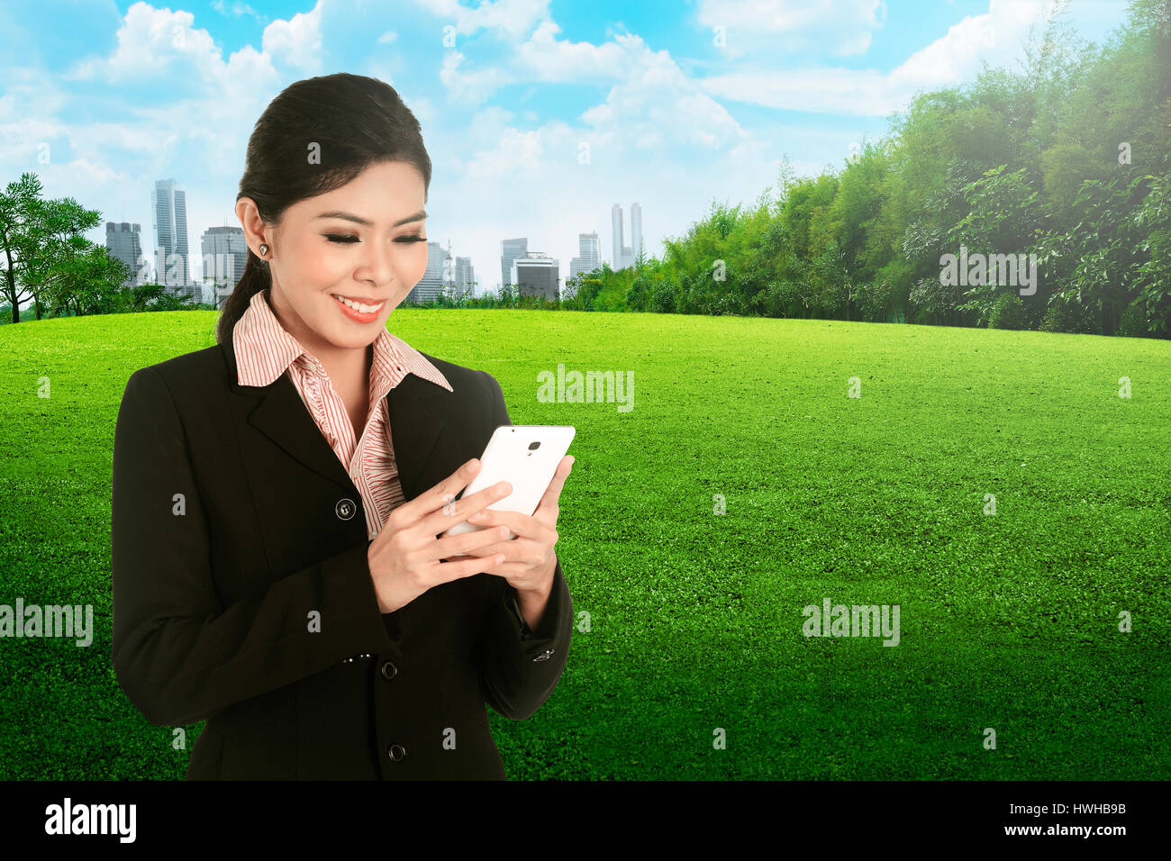 A Smiling asian business woman using cellphone on the city park Stock ...