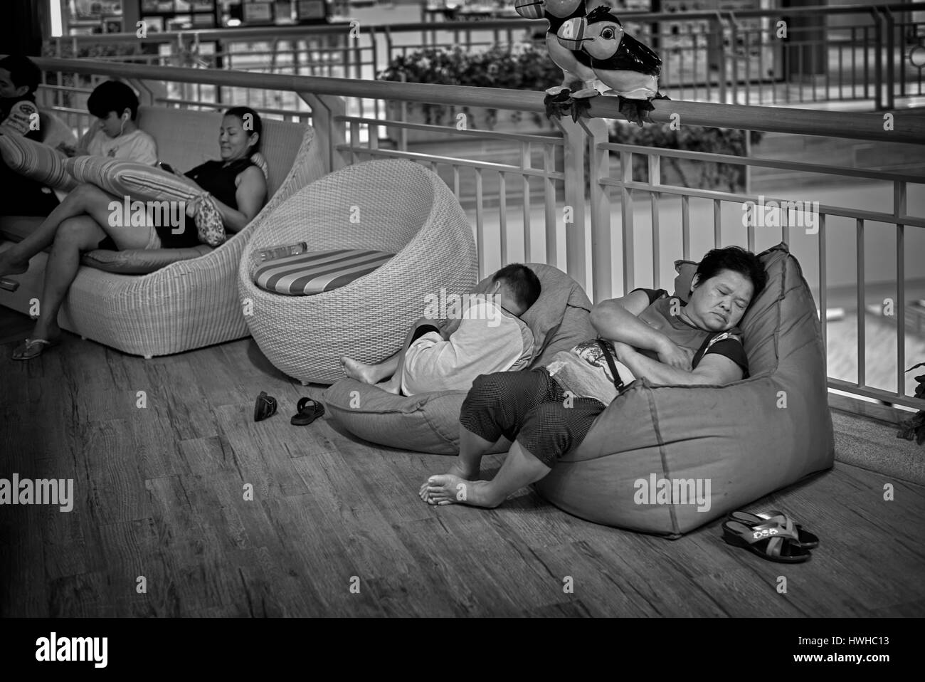 Thailand people sleeping and taking a mid day nap in the relaxing area of a local shopping mall black and white photography Stock Photo