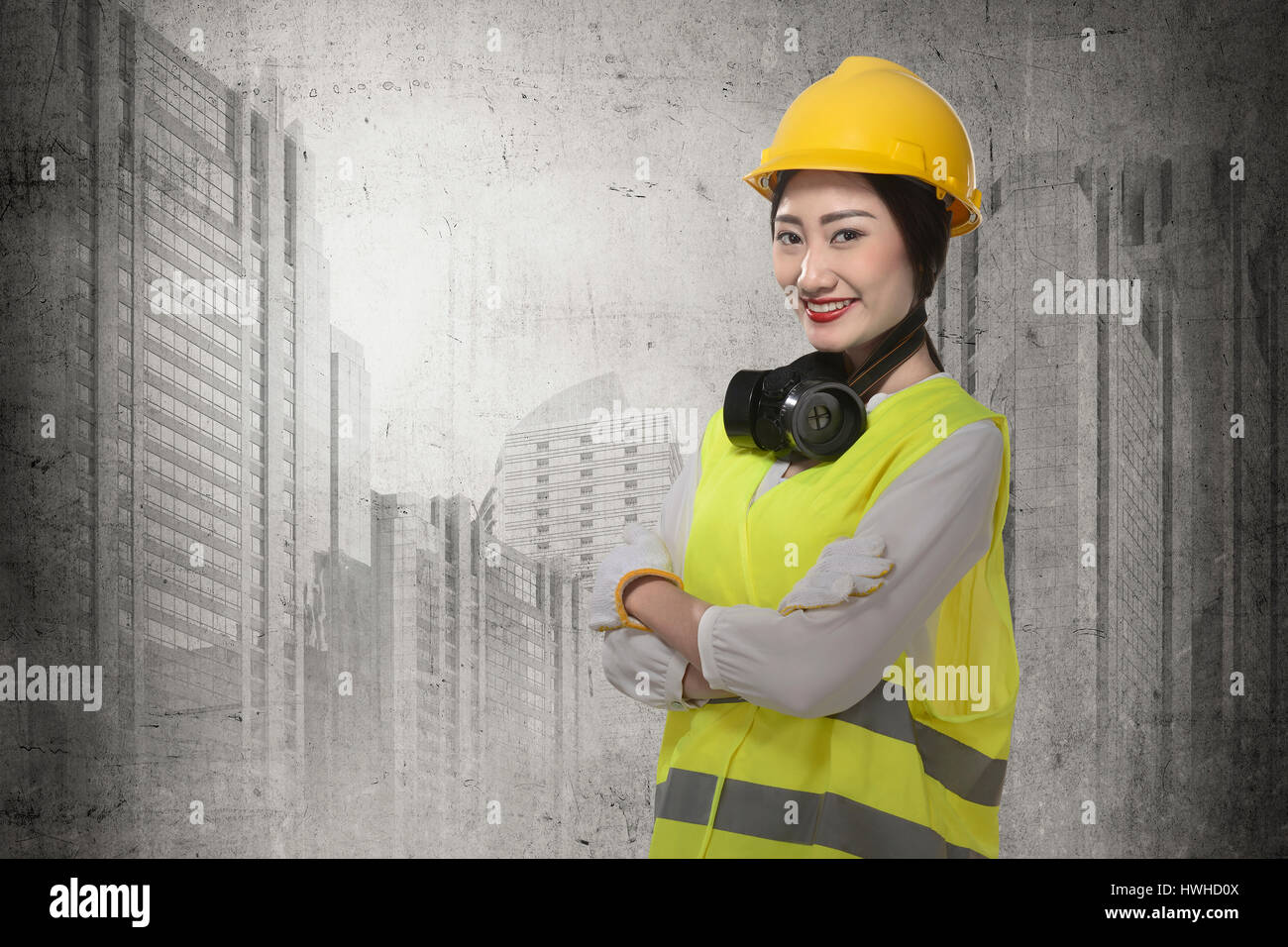 Asian business woman wearing yellow helmet smile over construction sites background Stock Photo