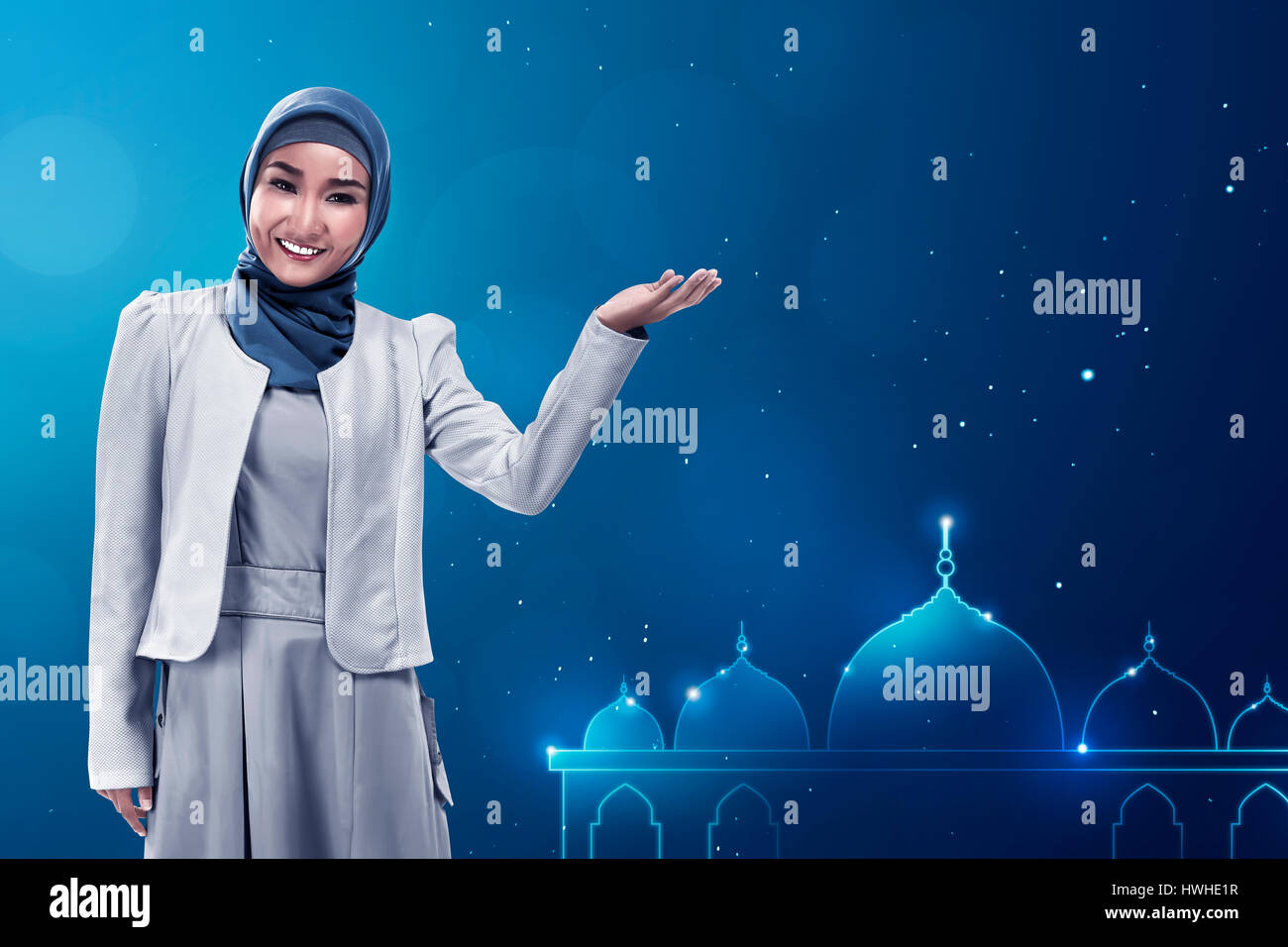 Young asian muslim woman give smile on mosque background with blue color, template your giftcard Stock Photo
