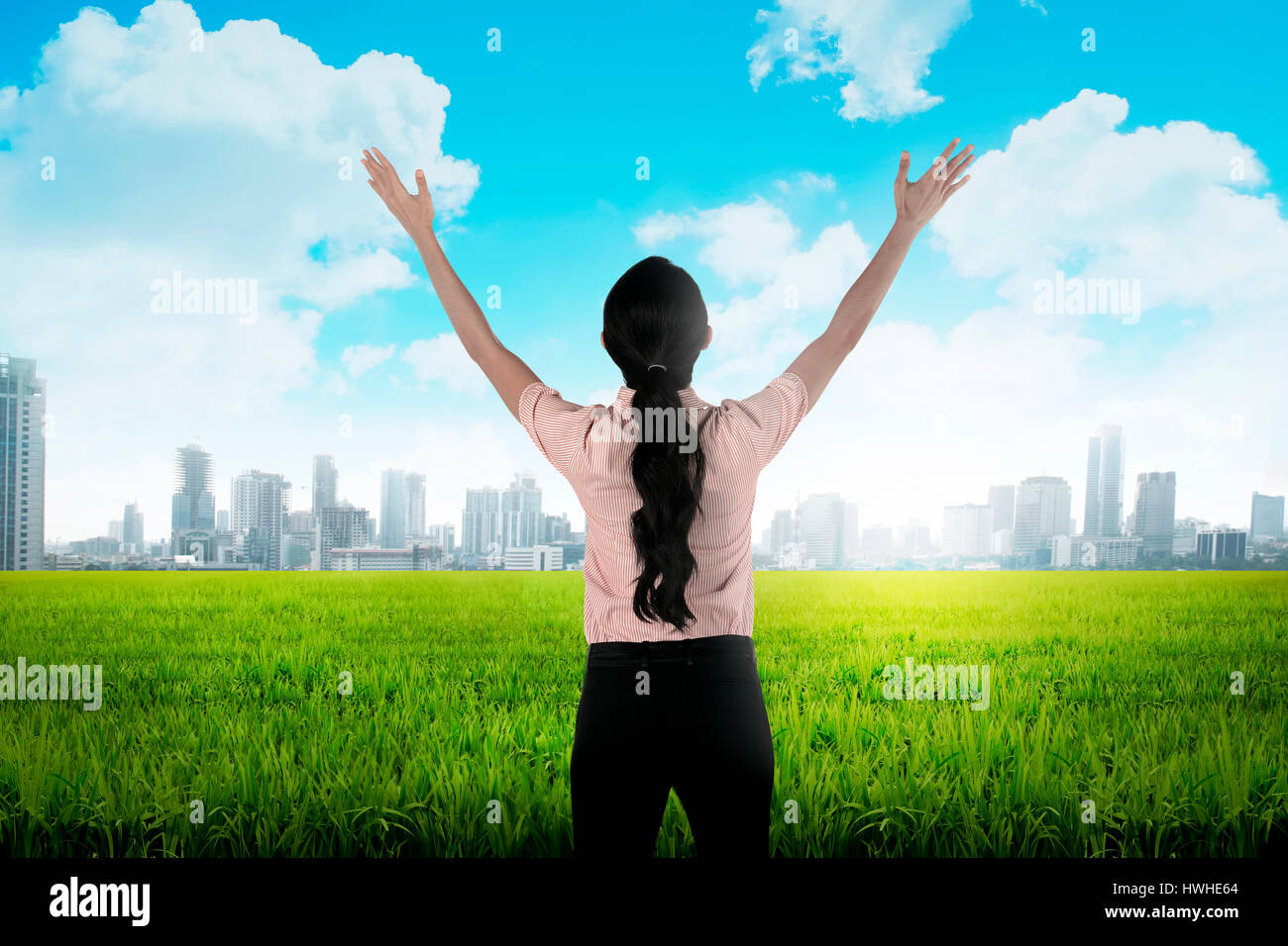 Backview of asian business woman looking the city while raise her hand ...