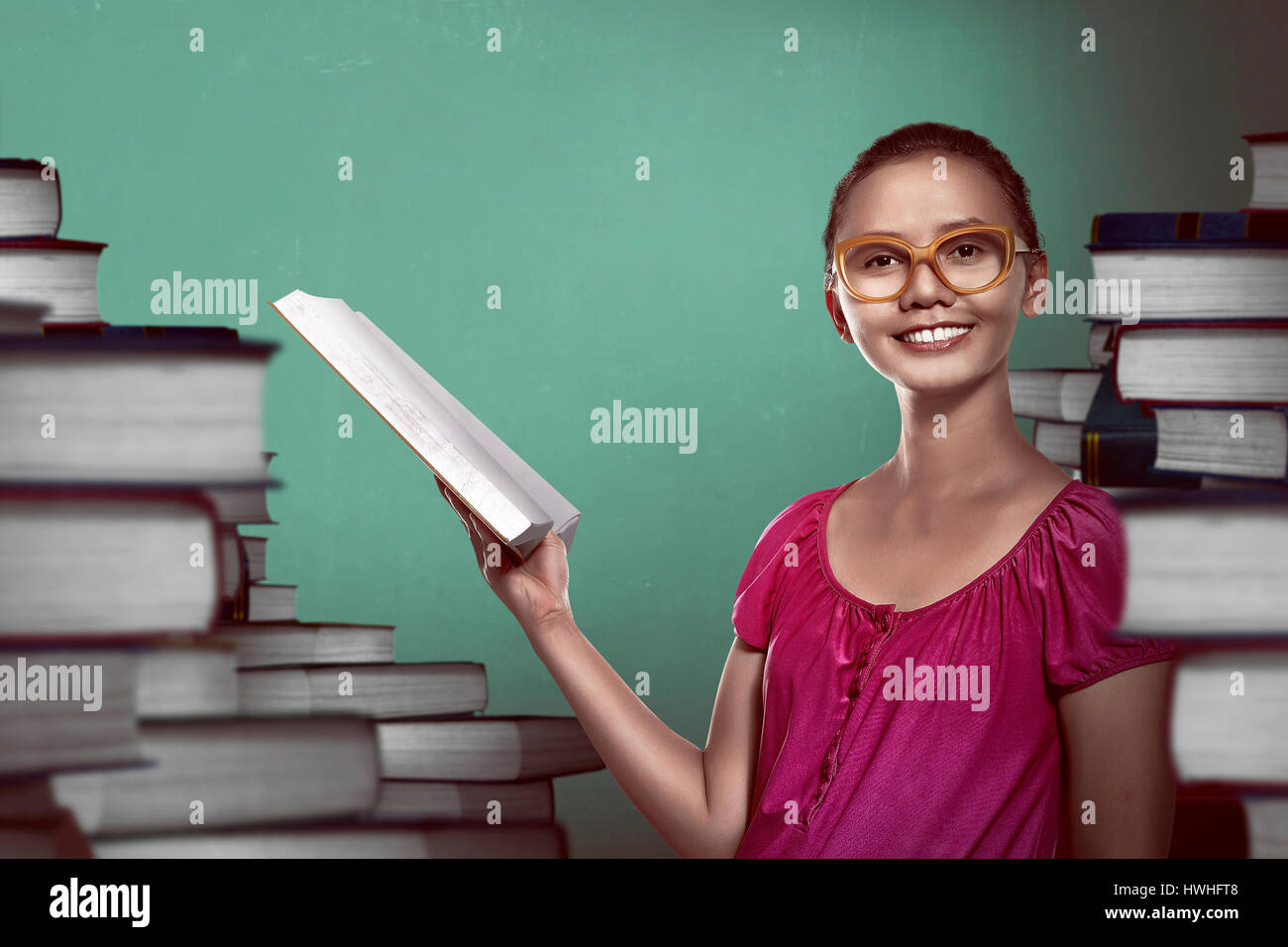 Image of asian female student holding book with books background Stock ...