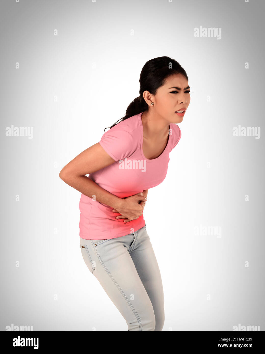 Young asian woman have stomach ache, with uneasy face Stock Photo