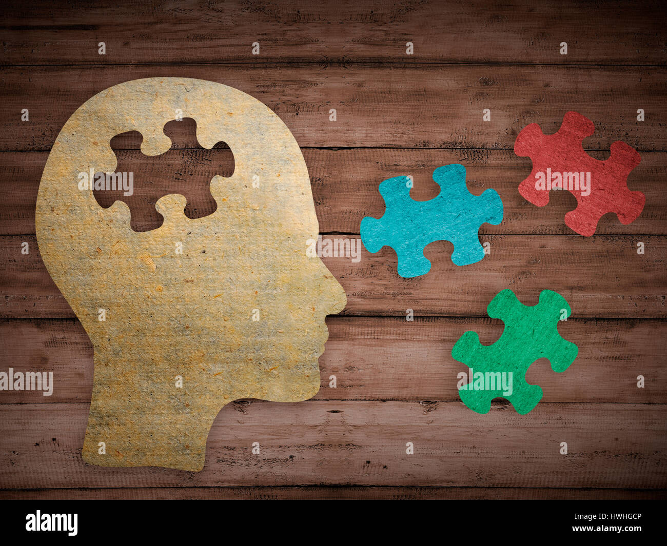 Puzzle head brain concept. Human head profile made from brown paper with a jigsaw piece cut out. Choose your personality that suit you Stock Photo