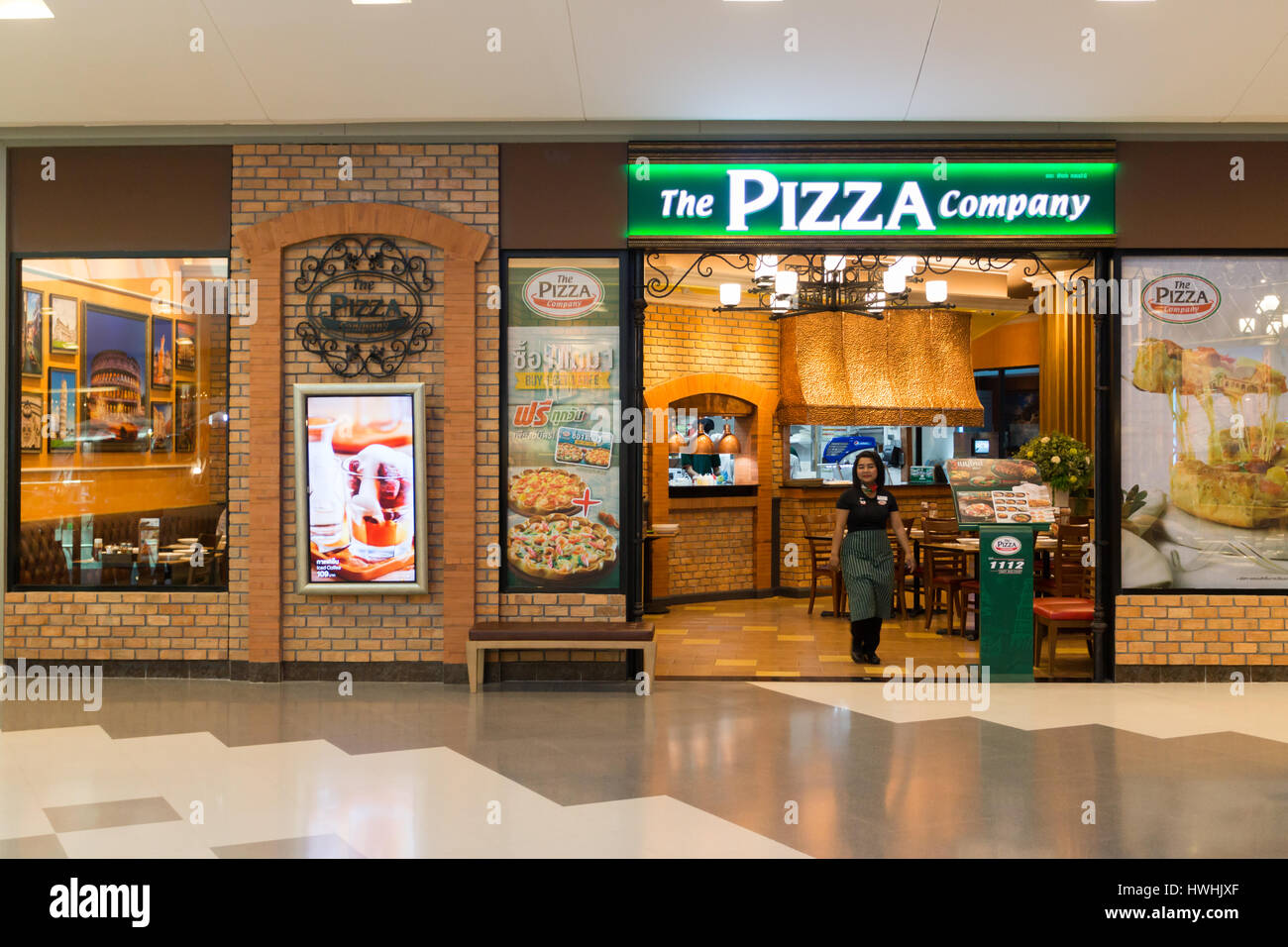 A waitress waits to greet customers at the Pizza Company restaurant in Central Festival mall in