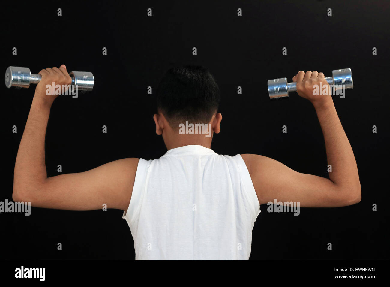 Boy at starting position for dumbbell press, back, workout, exercise