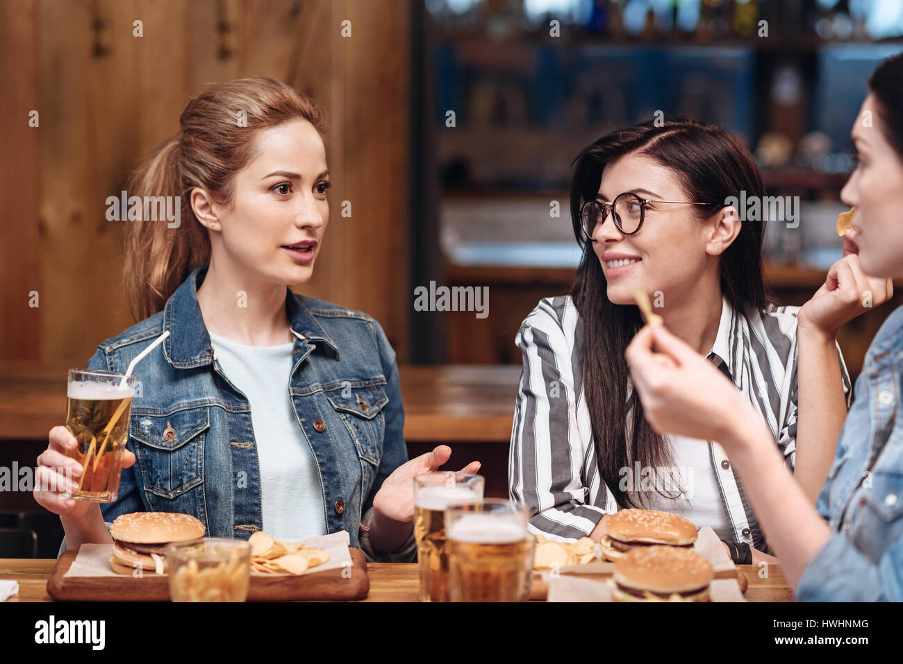 общение людей. красивые девушки шепчутся. девушка рассказывает историю подруге. девушка рассказывает про историю. общение двух людей.